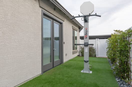 Model back yard of one of our apartments for rent in Peoria, AZ, featuring a lawn, fence, and exercise equipment.